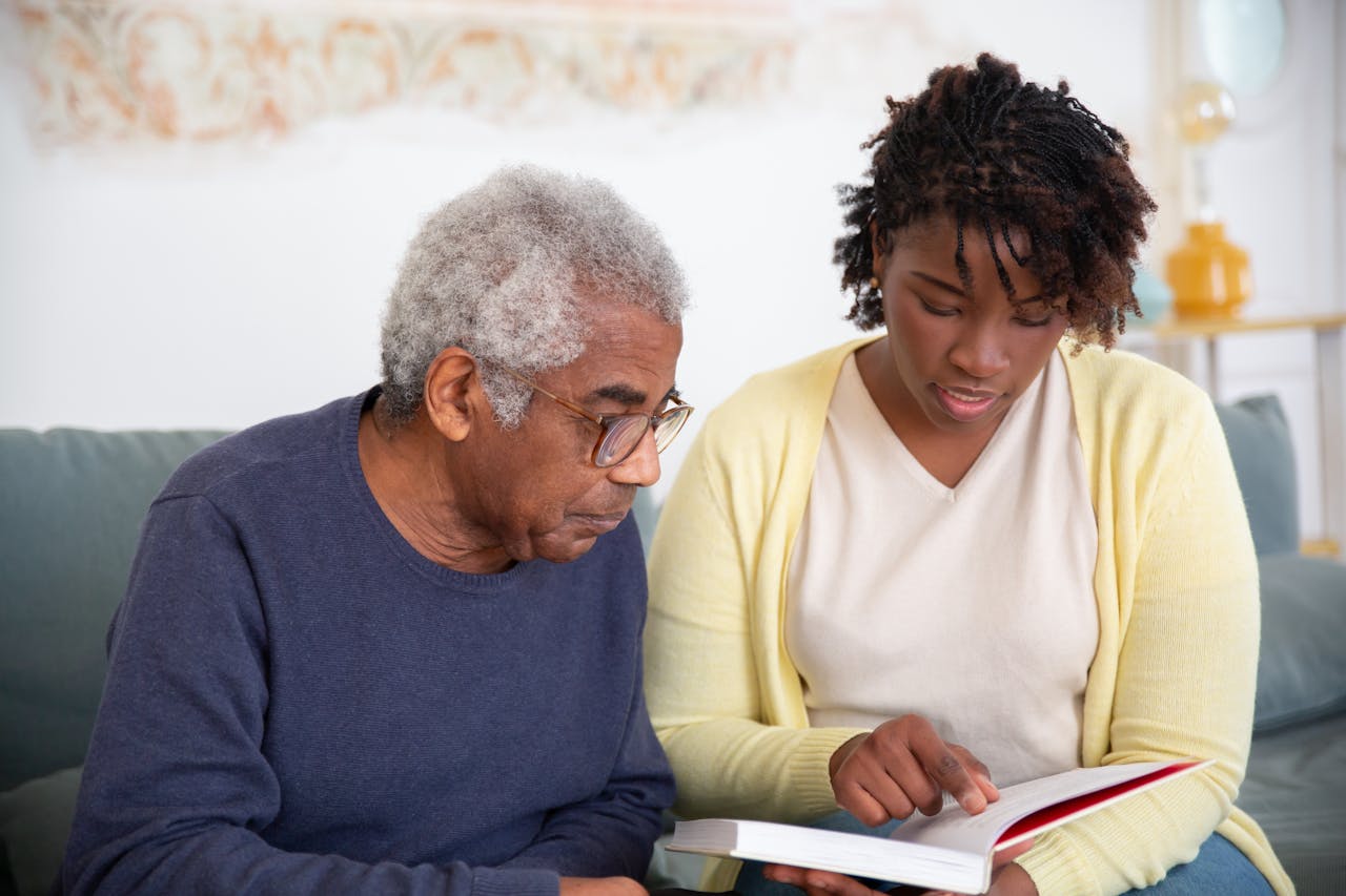 Mastering the First Impression: Your intriguing post title goes here A caregiver helps a senior man with reading, providing support at home.